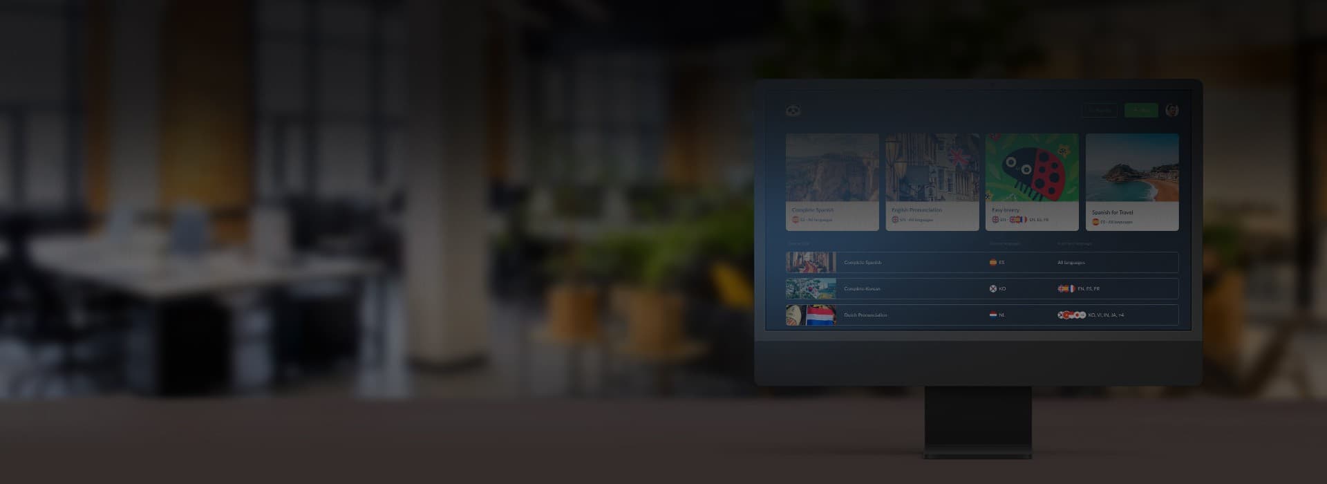 Desktop monitor showing a language learning platform CMS in an office