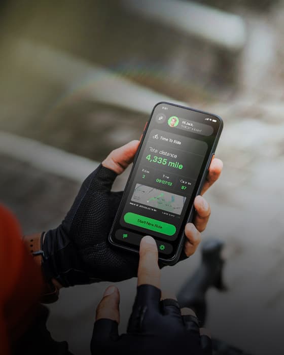 Cyclist holding a phone with a bike ride tracker app