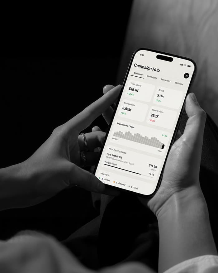 Hand holding a phone with a revamped adtech app