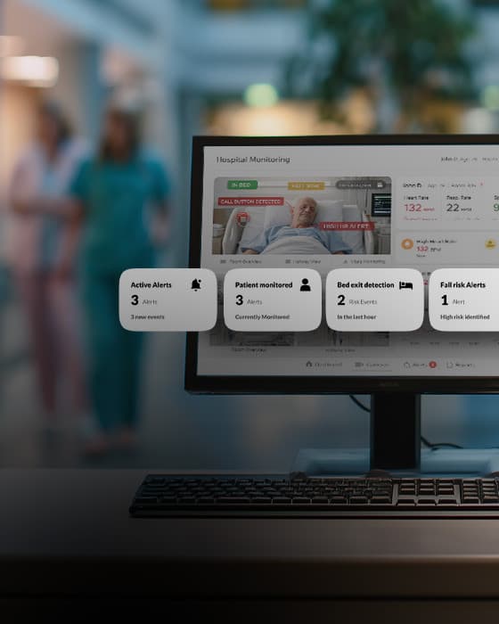 Hospital staff beside a real-time video monitoring screen