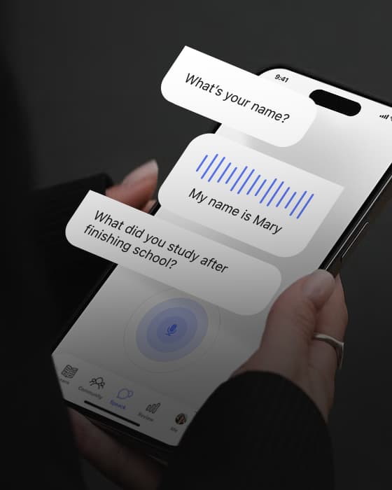 Hand holding a phone with an AI conversation in a language learning app